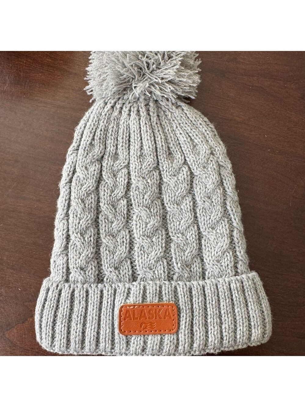 Gray Cable Knit Pom-Pom Hat with Alaska patch.